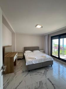 a bedroom with a bed and a desk and a window at Lüks Deniz ve Doğa Manzaralı Yazlık Ev in Dalaman