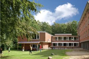 a group of people playing on the lawn in front of a building at Jugendherberge Flensburg in Flensburg