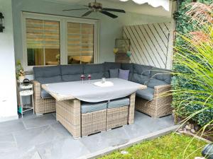 einen Tisch und Stühle auf einer Terrasse mit einem Sofa in der Unterkunft Bodenseeperle in Friedrichshafen