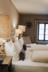 una camera da letto con letto con cuscini e orologio di Boutiquehotel Weisses Rössl a Innsbruck