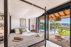 a bedroom with a bed with a view of a pool at Royal Tiki Lodges - Maison d'hôtes avec Piscine chauffée & SPA in Plaissan +29 photos