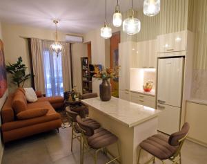 a kitchen with a table and chairs and a living room at Χρυσηίδα - Chrysiida Luxury Apartment in Nafplio