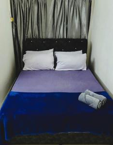 a bed with a blue blanket and pillows at booking homestay manjung 300mbps wifi in town in Seri Manjung