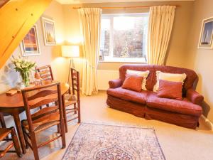 a living room with a couch and a table at Lavender Cottage in Louth