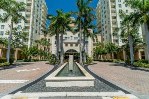 a fountain in the middle of a street with palm trees at The Palms Suite - Casa Costa 309S 1 Bedroom, Pools, Jacuzzi, Beach, Shops & Dog Friendly in Boynton Beach