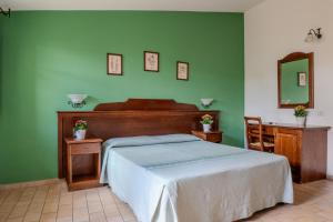 a bedroom with a bed and a green wall at Hotel Bia Maore in Baunei