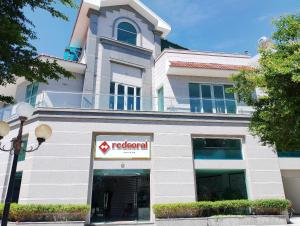 un edificio con un cartello rosso alle erbe di fronte di Red Coral Hotel a Phan Rang-Tháp Chàm