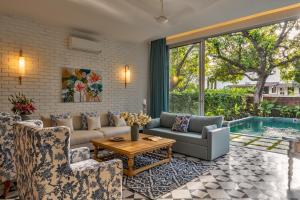 a living room with a couch and chairs and a pool at La Dora -3BHK Contemporary Villas with Pvt Pool, 5 mins Walk to Vagator beach-Caretaker & Garden in Vagator