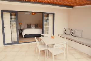 a bedroom with a bed and a table and chairs at Ochre and Ash in Clanwilliam +36 photos