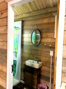 baño con lavabo en una pared de madera en Red Hibiscus Villas, en Rarotonga