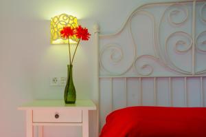 um quarto com um vaso com uma flor vermelha em Apartamento Junquera em Conil de la Frontera