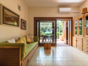 a living room with a green couch and a sliding glass door at Pinus Blissful Breeze in Pula +21 photos