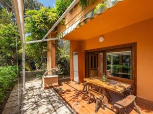 an orange house with a wooden table on a patio at Pinus Blissful Breeze in Pula