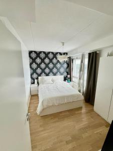 a bedroom with a white bed and a black and white wall at Samu's Castle in Hyvinkää