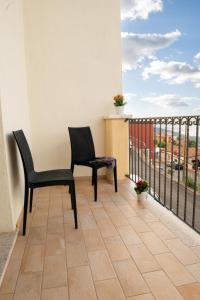 two chairs and a table on a balcony at Hotel Bia Maore in Baunei