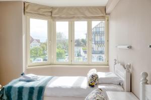 a bedroom with two beds and a large window at Stunning 3-Bedroom apartment with panoramic view in De Haan