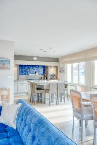 a living room with a blue couch and a table at Stunning 3-Bedroom apartment with panoramic view in De Haan