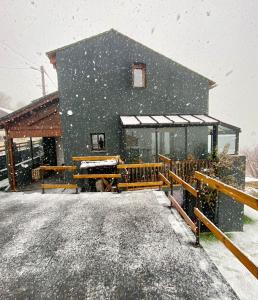a house covered in snow in front of a building at Valley Balcony in Enveitg