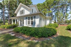 a white house with bushes in front of it at 1369 Laurel Grove "The Crows Nest" in Destin