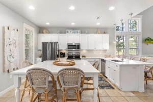 a kitchen with white cabinets and a table and chairs at 1369 Laurel Grove "The Crows Nest" in Destin
