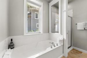 a white bathroom with a tub and a window at 1369 Laurel Grove "The Crows Nest" in Destin
