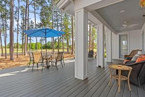 a porch with a table and chairs and a blue umbrella at 1369 Laurel Grove "The Crows Nest" in Destin