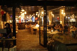 a restaurant with tables and people sitting at tables at פינה בראש מלונאות ותיירות in Rosh Pinna
