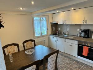 a kitchen with a wooden table and a dining room at Bijou Lungern in Lungern