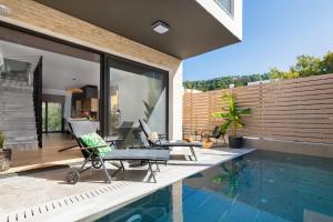 un patio avec deux chaises et une piscine dans l'établissement La Siesta Villas, à Ixia