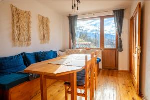 a living room with a table and a blue couch at Cozy Luxurious Apartment Next to Borovets and Rila mountain in Govedartsi