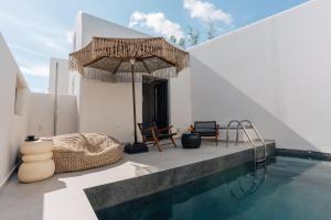 ein Haus mit Swimmingpool und Sonnenschirm in der Unterkunft Erthā Suites with private pools in Vóthon