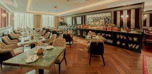 ein Restaurant mit Tischen und Stühlen und eine Bar in der Unterkunft Millennium Al Masar in Dschidda