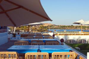 a group of tables with chairs and umbrellas at Dolty Kato Nubian House By Kato Dool in Aswan