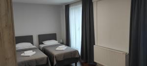 a bedroom with two beds and a window at Apartmani METRO in Loznica