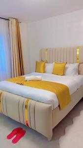 two beds in a room with yellow and white pillows at Haven Cozy homes Nax in Nakuru