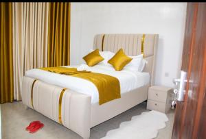 a white bed with yellow pillows in a bedroom at Haven Cozy homes Nax in Nakuru