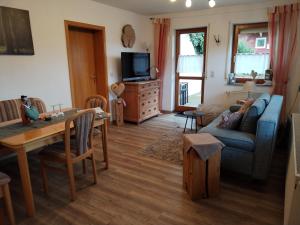 a living room with a blue couch and a table at Ferienwohnung Fahrner in Baiersbronn