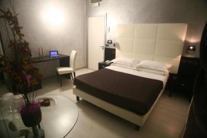 a bedroom with a bed and a desk with a laptop at Hotel Victoria in Porto San Giorgio