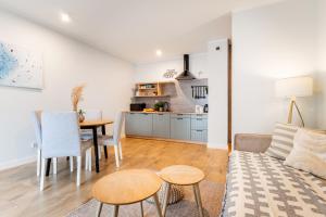 a living room and kitchen with a couch and a table at Marina Luna - widok na jezioro, parking podziemny, winda, Netflix, Max in Iława