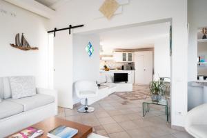 a living room with a white couch and a table at Villa Aurazure by Klodge in Olbia