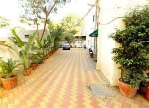 a car driving down a brick street with plants at Hotel Princess in Ankleshwar