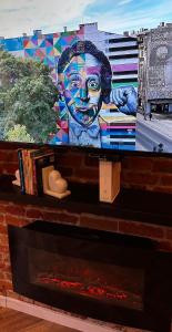 a television with a painting of a boy on it at Loft z Antresolą i Balkonem w Centrum Łodzi Przystań Jednorożca Klimatyzacja Faktura in Łódź