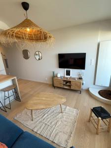 a living room with a couch and a table at Appartement face mer in Saint-Jean-de-Monts
