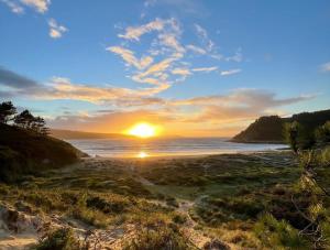 a sunset on a beach with the ocean at Grupo Gontad Apartamento Mourelle Corme in Corme-Puerto +12 photos