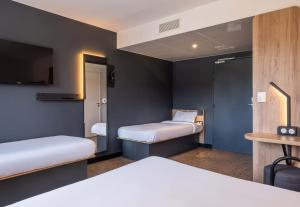 a small room with two beds and a tv at B&B HOTEL Evian Publier in Publier