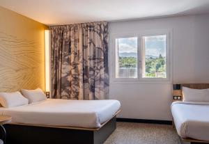 a hotel room with two beds and a window at B&B HOTEL Evian Publier in Publier +21 photos