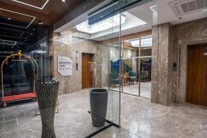 a lobby with a large glass door with a sculpture at The Kleo Hotel in Zirakpur