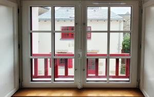 una stanza vuota con una finestra che si affaccia su un edificio di Le clos du prieuré - Les Gîtes de la Côte d'Amour a Batz-sur-Mer Altre 16 foto