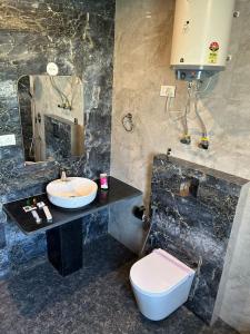 un baño con lavabo e inodoro en LN Grand Suite, en Manali