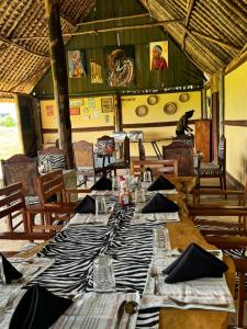 a dining room with a table with plates and napkins at Amboseli Discovery Camp in Amboseli